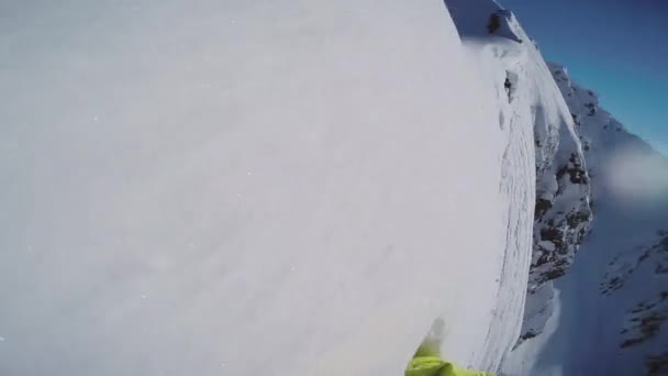 スノーボーダーが雪に覆われた山の上に起きます。極端な。頭の上には、プロのカメラを移動します。太陽 — ストック動画