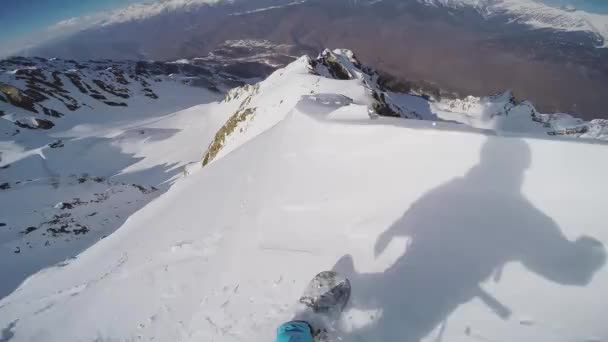 Snowboarder giro nel backcountry dalla cima della montagna. Giornata di sole. acrobazia estrema — Video Stock