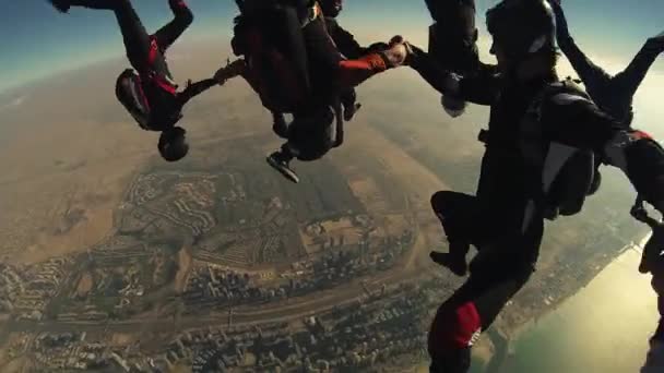 Ντουμπάι, Ηνωμένα Αραβικά Εμιράτα - 10 Φεβρουαρίου 2014: Skydivers κάνουν σχηματισμό πάνω από το Ντουμπάι στο ουρανό. Ηλιόλουστη μέρα. Ακραίο άθλημα. Αστικό τοπίο — Αρχείο Βίντεο