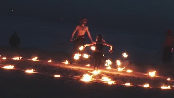 SAN PETERSBURG, RUSIA - 14 DE JUNIO DE 2007: Mujer vestida de cuero y dos hombres realizan un espectáculo de fuego en la playa dentro de un círculo ardiente. Fiesta. — Vídeos de Stock