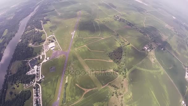 Skydiver paracadutismo sopra i campi verdi. Fiume. Estrema attività. Adrenalina . — Video Stock