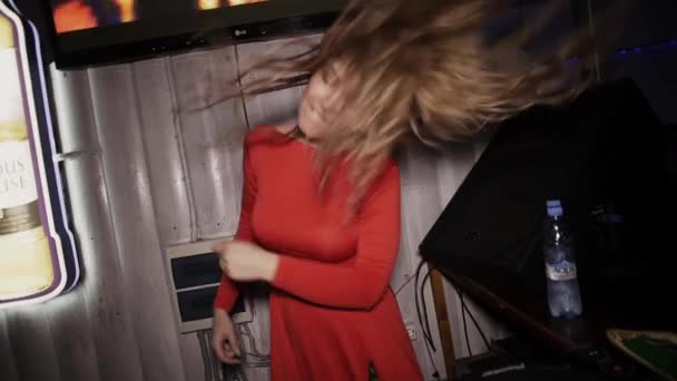SAINT PETERSBURG, RUSSIA - 17 GIUGNO 2016: Dj girl in abito rosso danza al giradischi in discoteca. Prestazioni. Agitare i capelli — Video Stock