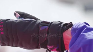 Soçi, Rusya - 7 Nisan 2016: Kız Kayak üniformalı Kayak Merkezi siyah eldiven koymak. Spor olay. Dağlar