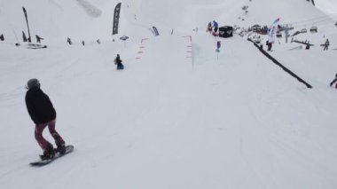 Soçi, Rusya - 7 Nisan 2016: Kayak Merkezi. Teen snowboard binmek sıçrama tahtası. Güneşli. Karton kozmik nesne