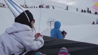 Soçi, Rusya - 7 Nisan 2016: Küçük kız hava balonu yalanla folyo yapılmış şapkalı. Teen snowboard ride.