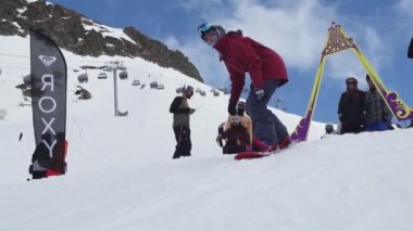 Soçi, Rusya - 7 Nisan 2016: Snowboarder atlama sıçrama tahtası ve yamaç binmek. İnsanlar. Kayak Merkezi. Güneşli