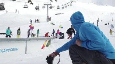 Soçi, Rusya - 7 Nisan 2016: Snowboarder slayt üzerinde iz. Karton kozmik objeler. Kameraman. Güneşli gün.