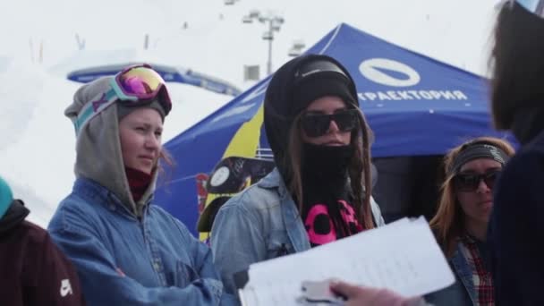 SOCHI, RUSIA - 7 DE ABRIL DE 2016: Mujer en chiste sombrero con carpeta explicar algo a las niñas en la estación de esquí. Encamp. . — Vídeos de Stock