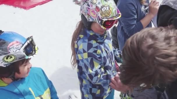SOCHI, RUSIA - 7 DE ABRIL DE 2016: Hombre comprobar el uniforme de esquí de la adolescente en la estación de esquí. Evento de entretenimiento. Deporte — Vídeos de Stock