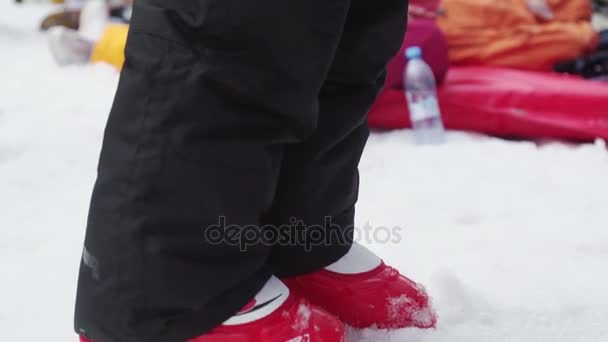 Soči, Rusko - 7. dubna 2016: Malá holčička v ski jednotný, sluneční brýle drží balon na lyžařské středisko. Lidé — Stock video
