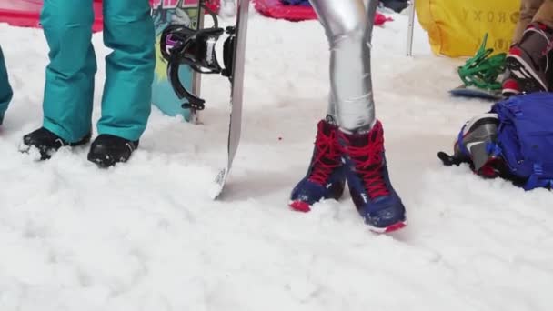 SOCHI, RUSSIA - 7 APRILE 2016: Ragazza bionda in costume cosmico incandescente sul comprensorio sciistico tiene lo snowboard. Sorridi — Video Stock