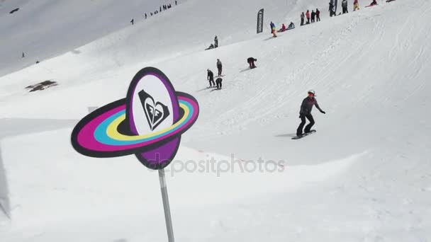 СОЧИ, РОССИЯ - 7 апреля 2016 года: Горнолыжный курорт. Юный сноубордист прыгает с трамплина. Сун. Картонный космический объект — стоковое видео