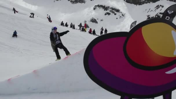 Sochi, Rusko - 7. dubna 2016: Teen snowboardista skok z odrazový můstek. Lepenkové kosmické objekty. Lidé — Stock video