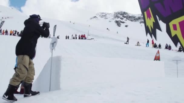 SOCHI, RÚSSIA - 7 de abril de 2016: Adolescente snowboarder fazer flip de trampolim. Cartão objetos cósmicos. Cameraman — Vídeo de Stock