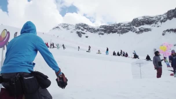 SOCHI, RUSIA - 7 DE ABRIL DE 2016: Camarógrafo disparar snowboarder salto desde el trampolín. Gente. Estación de esquí. Extremo. — Vídeos de Stock