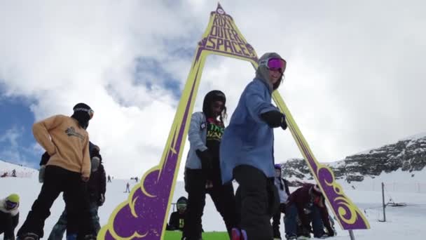 СОЧИ, РОССИЯ - 7 апреля 2016 года: Сноубордисты едут с космической арки на трамплине. Людей. Лыжный курорт. Горы — стоковое видео