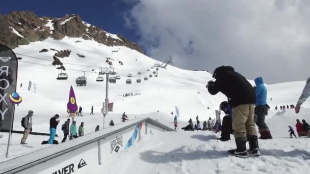 Sochi, Rusko - 7. dubna 2016: Snowboardista jízda na železnou stezkou. Lyžařské středisko. Lidé. Slunečný den. Extrémní sport — Stock video