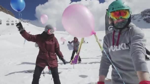 SOCHI, RUSIA - 7 DE ABRIL DE 2016: Snowboarders y esquiadores viajan con globos aéreos en las manos. Estación de esquí. Evento — Vídeos de Stock