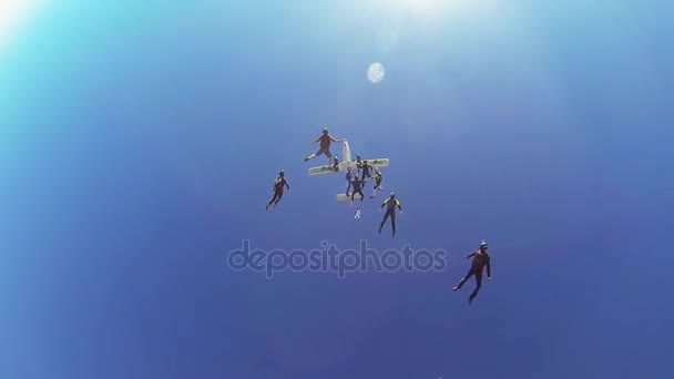 Dubai, Förenade Arabemiraten - 11 februari 2014: Professionella fallskärmshoppare hoppa från flygplan, göra bildning över Dubai. Soligt. — Stockvideo