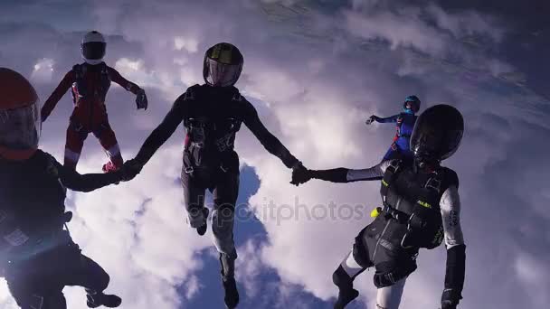 SEVILLE, ESPANHA - 21 de maio de 2013: Paraquedistas fazem formação no céu. De mãos dadas no ar. Nuvens no céu azul . — Vídeo de Stock