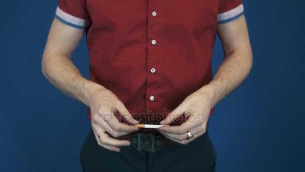 Cerca de mago en camisa roja realizar truco de magia desaparecer en las manos cigarrillo — Vídeos de Stock