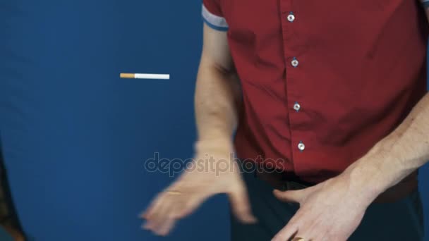 Закрыть волшебник в красной рубашке телекинез фокус сигарета летит — стоковое видео