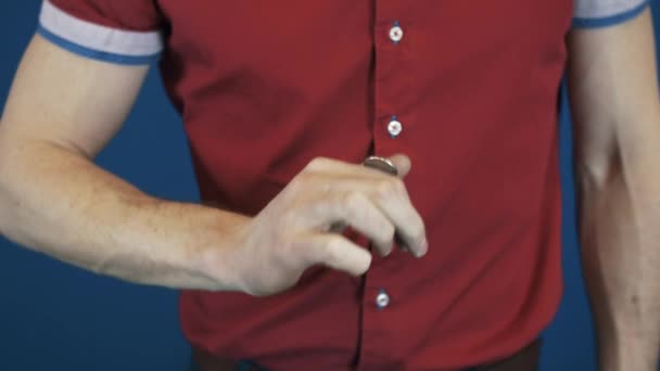 Cerca de mago en camisa roja moneda de lanzamiento rápido con los dedos — Vídeos de Stock