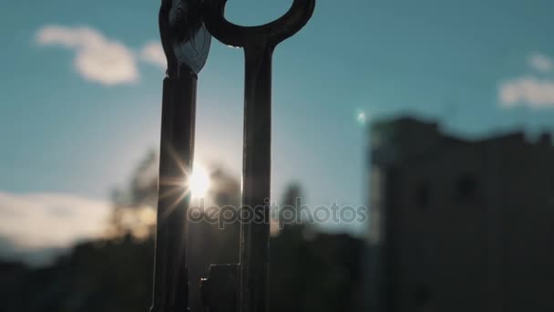Slowmotion close up door keys hanging outside in bright sun. Blurred building — Stock Video