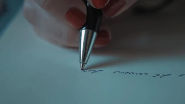 Close-up van tikje vrouwelijke hand rode nagellak schrijven met pen op gewoon papier — Stockvideo