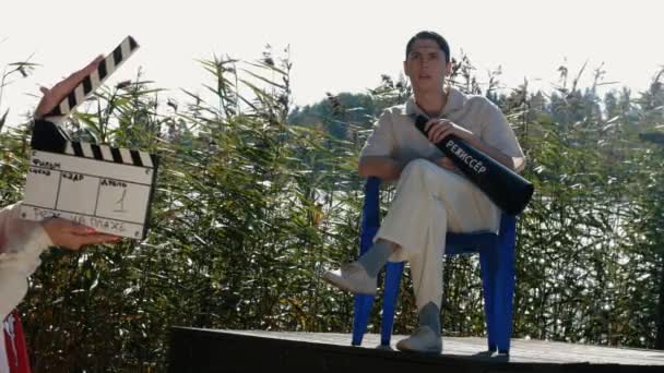 Αντιδρούν συναισθηματικά Clapper μπροστά από σκηνοθέτης της ταινίας, με τα μαλλιά καθαρά άσπρα ρούχα — Αρχείο Βίντεο