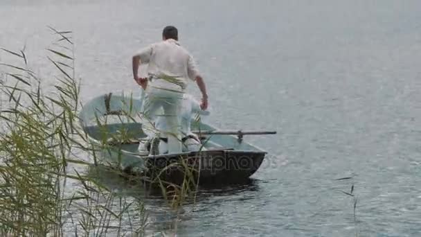 Mens in witte kleren met megafoon help paarlemoeren plaats in boot zonnige zomerdag — Stockvideo