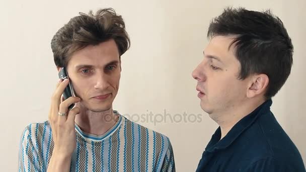 Zwei besorgte Männer stehen im weißen Saal und telefonieren mit dem Handy — Stockvideo