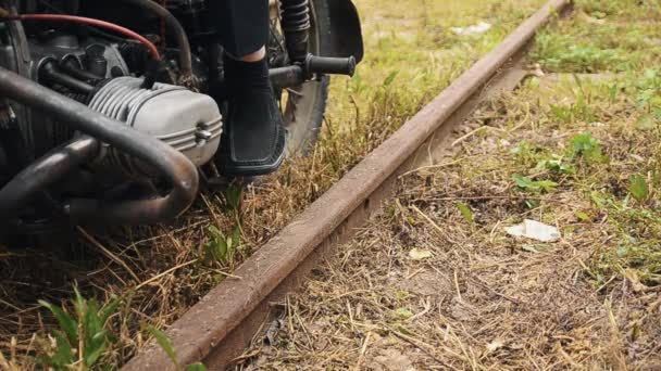 Hombre en pantalones a medida que sale de la motocicleta en el ferrocarril — Vídeos de Stock