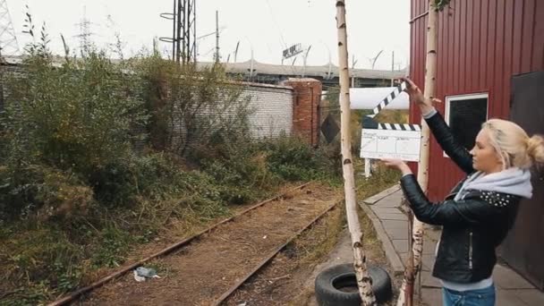 O diretor de cinema preocupado corre para treinar o caminho de ferro e embarca nele. Clapper menina bordo — Vídeo de Stock