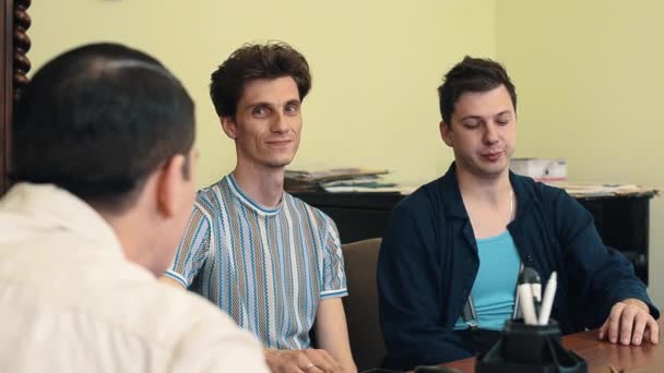 Mann mit Haarnetz erschreckt zwei Besucher bei Bürotreffen — Stockvideo