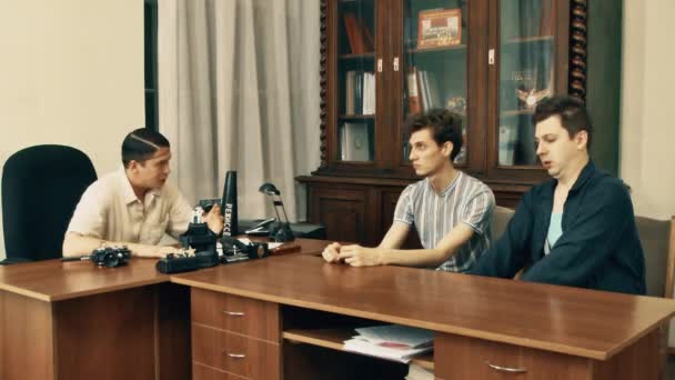 Σκηνοθέτης της ταινίας στα μαλλιά καθαρά θυμωμένος ανάγνωση σεναρίου με γραφείο εργάτες πάνω από — Αρχείο Βίντεο