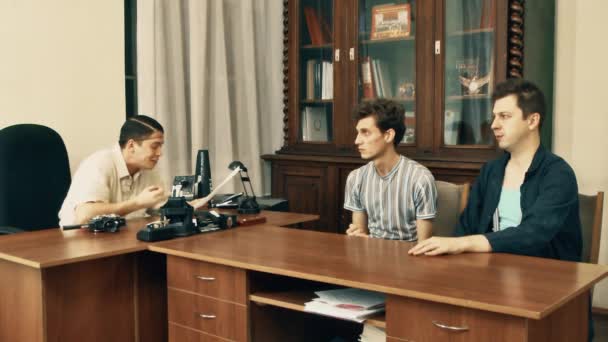 Filmový režisér v bílé tričko rozzlobený, s office dělníci probírali scénář — Stock video