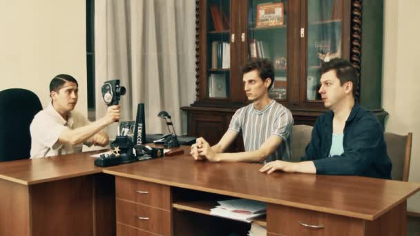 Hombre en ropa blanca utilizar retro cámara de 8 mm en la oficina de tiro visitante — Vídeo de stock