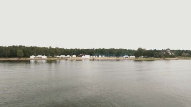 Hava atışı beyaz çadır ve spor zemin ile Sahil plaj deniz üzerinde uçan