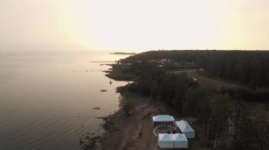 Havadan görünümü kum deniz sahilinde beyaz çadır ve gün batımı zemin spor ile orman