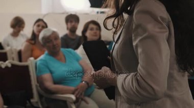 Saint Petersburg, Rusya - 23 Haziran 2016: Kadın eski konser salonu koltuklarda oturan insanlarla konuşarak tablet ile