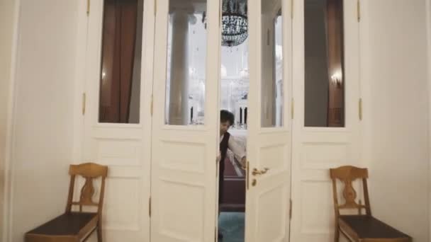 SAINT PETERSBURG, RUSSIE - 23 JUIN 2016 : Vieille femme en mouvement ouvre les portes dans le hall d'orgue lumineux vide avec beaucoup de sièges — Video