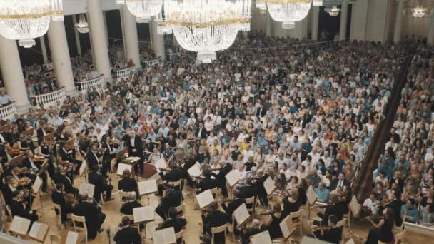 САЙНТ-ПЕТЕРБУРГ, РОССИЯ - 23 июня 2016 года: Струнный оркестр играет на сцене классического концертного зала, много людей — стоковое видео