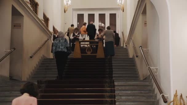 SAINT PETERSBURG, RUSSIA - JUNE 23, 2016: People walk up staircase in old style classical concert hall corridor interior — Stock Video