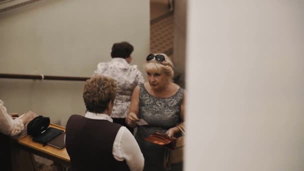 圣彼得堡，俄罗斯-2016 年 6 月 23 日︰ 用手里的票的女人说话迎接老风格音乐厅在楼梯上 — 图库视频影像