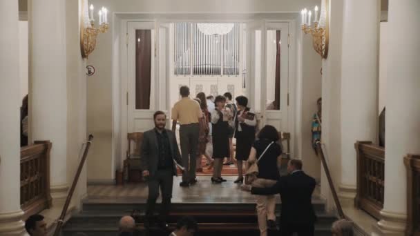 СЕНТ-ПЕТЕРБУРГ, РОССИЯ - 23 ИЮНЯ 2016: толпа поднимается по лестнице на концерт в органном зале, интерьер в классическом старом стиле — стоковое видео