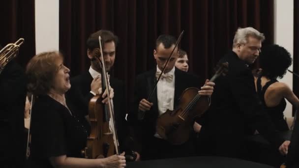 Sankt Petersburg, Ryssland - 23 juni 2016: Musiker med violiner talar före konserten. Svart kavaj, vit skjorta fluga — Stockvideo