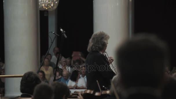 SAINT PETERSBURG, RUSSIA - JUNHO 23, 2016: músico líder da orquestra de cordas se preparando para o concerto no salão de música de estilo clássico — Vídeo de Stock