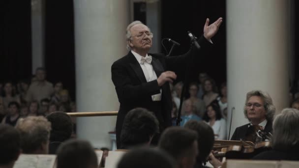 Sint-Petersburg, Rusland - 23 juni 2016: Wit-haired kapelmeester en viool orchestra in klassieke concertzaal — Stockvideo