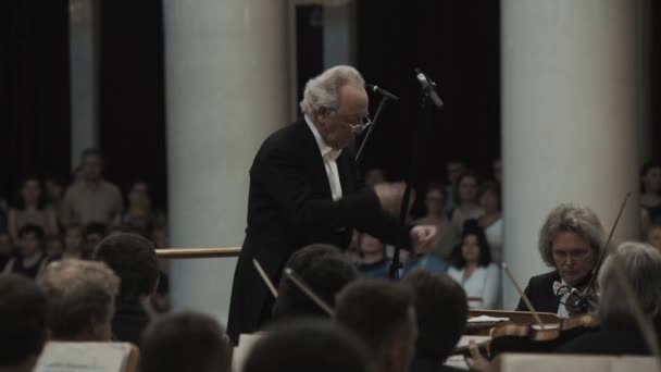 SAINT PETERSBURG, RÚSSIA - JUNHO 23, 2016: Kapellmeister de cabelos grisalhos que lidera a orquestra de violino na clássica sala de concertos — Vídeo de Stock